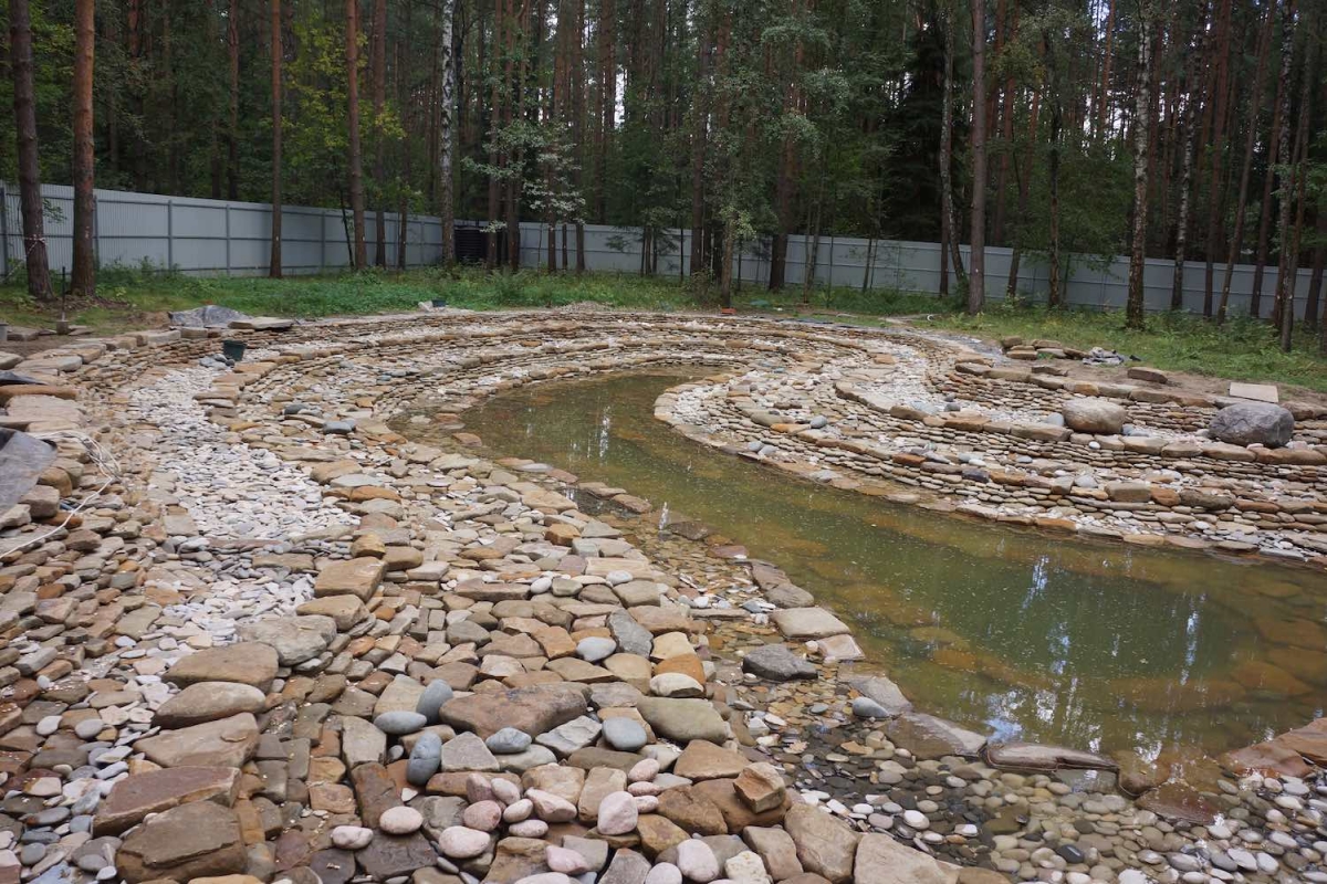 Укладка природного камня на дно и стены водоема